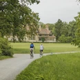 Schloss Cecilienhof im Neuen Garten Radfahrende im Neuen Garten am Schloss Cecilienhof im Sommer