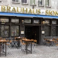 Brewery Sion Außengastronomie vor dem Brauhaus . An der Fassade steht in goldenen Buchstaben Brauhaus Sion.Outdoor dining in front of the Brauhaus . The words Brauhaus Sion are written on the façade in gold letters.
