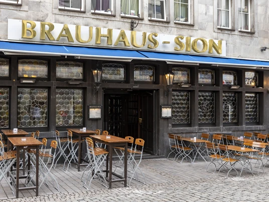 Brewery Sion Außengastronomie vor dem Brauhaus . An der Fassade steht in goldenen Buchstaben Brauhaus Sion.Outdoor dining in front of the Brauhaus . The words Brauhaus Sion are written on the façade in gold letters.