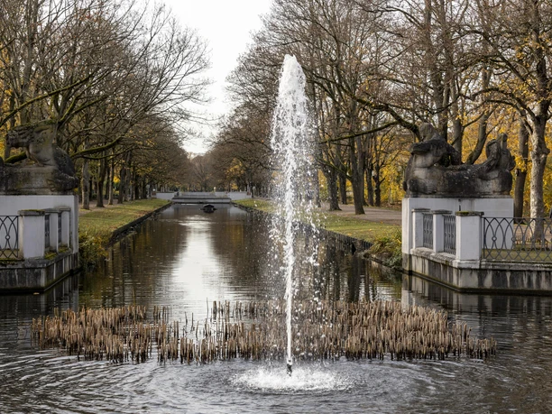 Rautenstrauchkanal Herbstlicher Lindenthaler Kanal mit sprudelndem Brunnen im Vordergrund, flankiert von Löwenskulpturen.