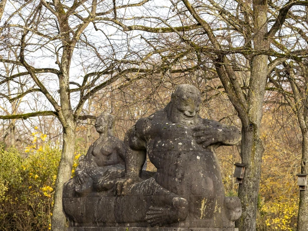 Rautenstrauchkanal Stone figure on the Lindenthal Canal sits on a plinth, surrounded by bare trees and reflected in the water.