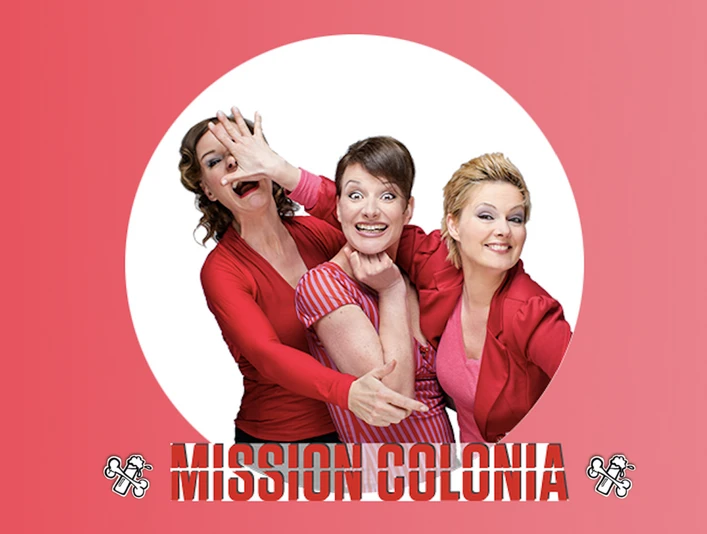 MC Logo Drei lachende Frauen in Rot, posierend vor einem weißen Kreis auf rotem Hintergrund mit "Mission Colonia".</p>Three smiling women in red, posing in front of a white circle on a red background with "Mission Colonia".</p> <p