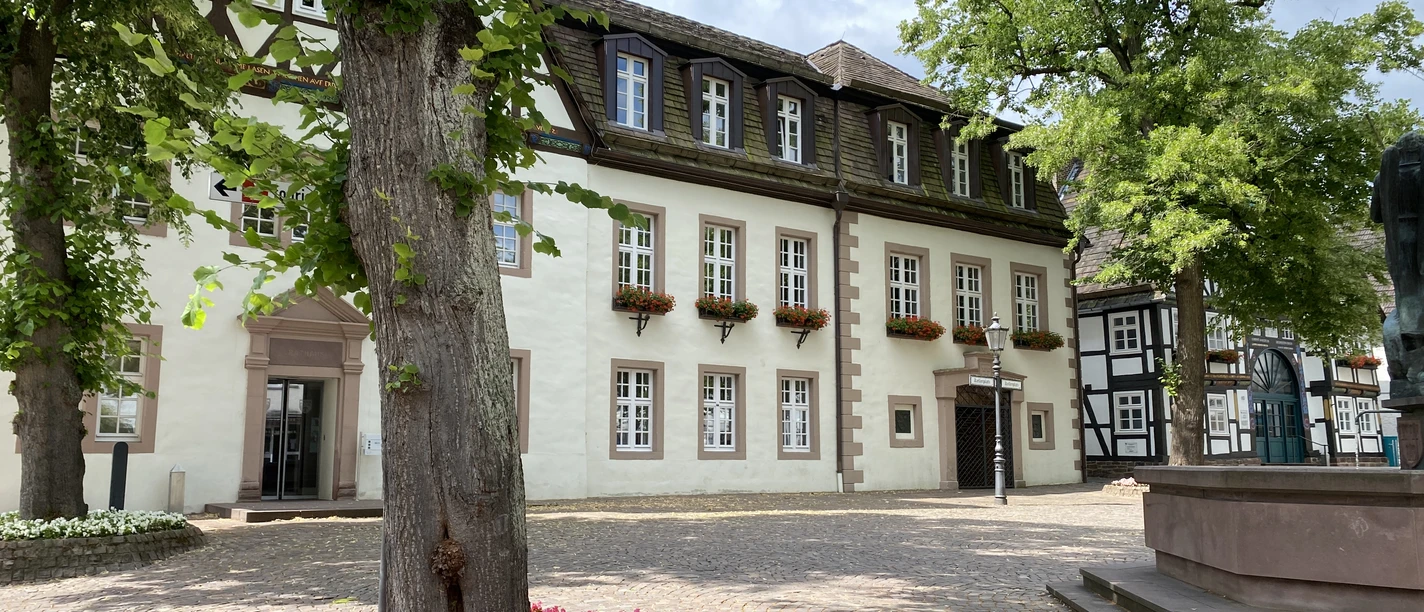 Rathaus Beverungen Historisches Rathaus Beverungen, umgeben von Bäumen und Blumen, mit Fachwerk und gepflegtem Platz.