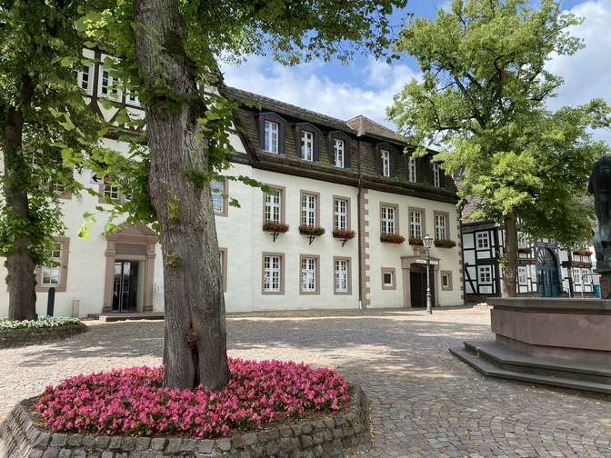 Rathaus Beverungen Historisches Rathaus Beverungen, umgeben von Bäumen und Blumen, mit Fachwerk und gepflegtem Platz.