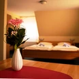 Havergoh Hotel_Doppelzimmer.jpg Zweibettzimmer mit Holzinterieur, Blumen in weißer Vase auf Tisch im Vordergrund, Tageslichtfenster.