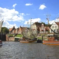 Hafen von Greetsiel Kutter, Wasser, Gebäude, historische Häuserzeile, blauer Himmel