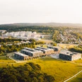 Hochschule und Universität Bielefeld.jpg Luftaufnahme eines modernen Campus in grüner Umgebung, mit weitläufigen Wiesen und Gebäudekomplex.