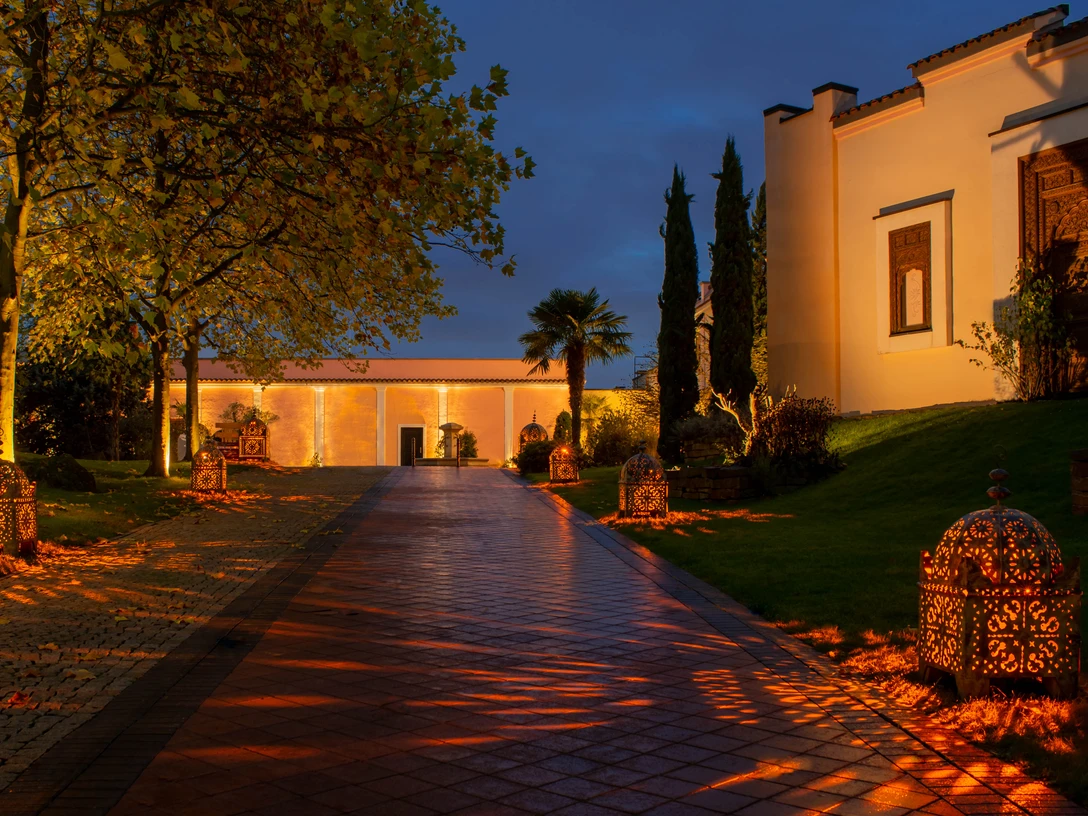 Mediterana Gebäude bei Nacht mit beleuchtetem Gehweg und Laternen in Bergisch Gladbach.