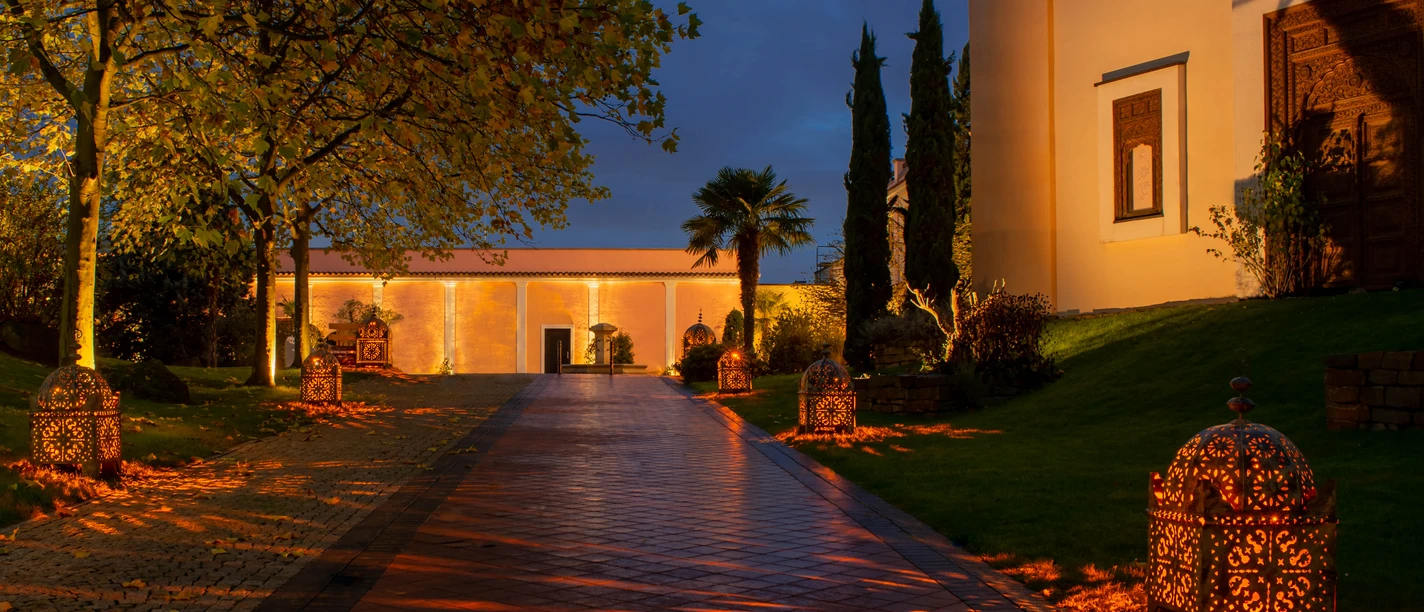 Mediterana Gebäude bei Nacht mit beleuchtetem Gehweg und Laternen in Bergisch Gladbach.