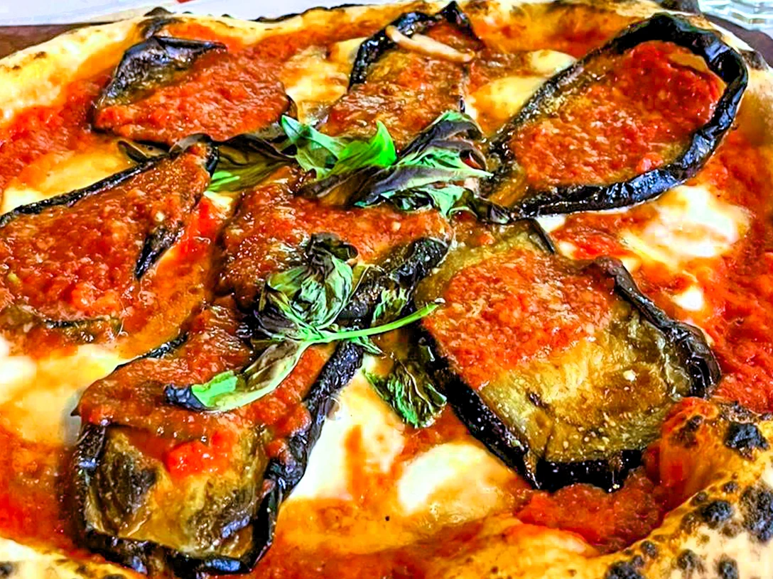 Pizza_CCBYSA_Teutoburger Wald_Stadt Schloss Holte-Stukenbrock-27.jpg Pizza mit gebratener Aubergine, frischer Tomatensoße, Mozzarella und Basilikum auf knusprigem Teig.