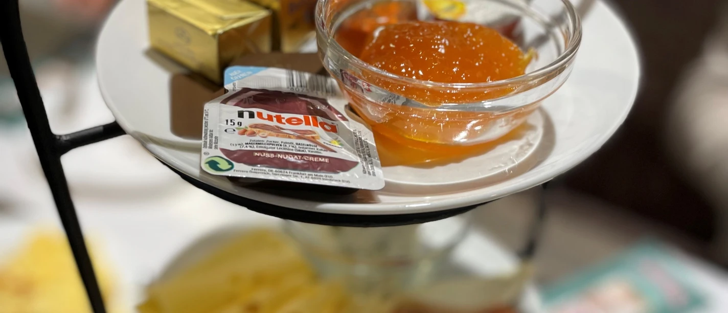 Frühstücks_Etagere_CC_BY_SA_Teutoburger_Wald_Stadt_Schloss_Holte-Stukenbrock.jpg Eine Etagere mit Käse, Gebäck, Marmelade und Nutella, arrangiert für ein Frühstück.