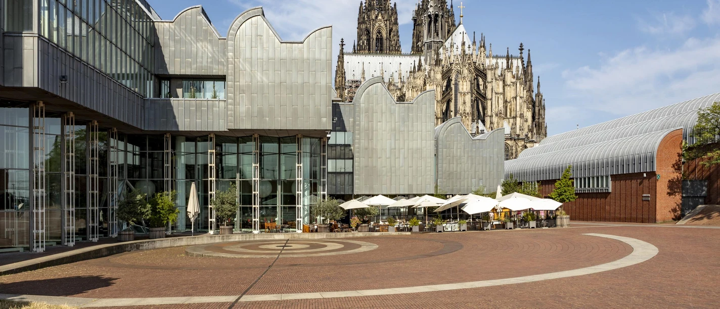 Museum Ludwig mit dem Kölner Dom im Hintergrund, bei klarer Himmelssituation.