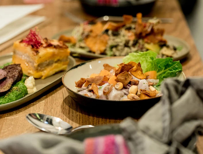 Tigermilch Das Bild zeigt einladende Teller mit kreativ angerichteten, frischen Gerichten und farbenfrohen Zutaten auf einem hölzernen Tisch bei warmem Licht.The image depicts inviting plates with creatively presented, fresh dishes featuring colorful ingredients, set on a wooden table under warm lighting.