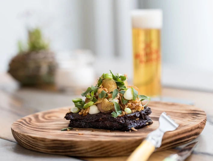 NeoBiota Ein kunstvoll angerichtetes Gourmetgericht mit frischen Kräutern und einem köstlichen Getränk im Hintergrund. An artfully arranged gourmet dish with fresh herbs and a delicious drink in the background.