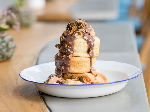 Neobiota A creative dish on a table in a stylish café, decorated with cacti in the background.