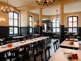 Max Stark Ein stilvoller Innenraum eines traditionellen Restaurants. Dunkle Holzmöbel und große Fenster dominieren das elegante Ambiente.A stylish interior in a traditional restaurant. Dark wood furniture and large windows dominate the elegant ambience.