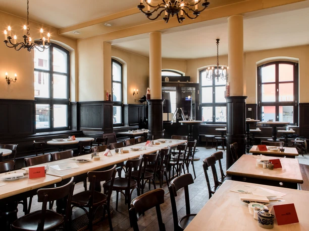 Max Stark A stylish interior in a traditional restaurant. Dark wood furniture and large windows dominate the elegant ambience.