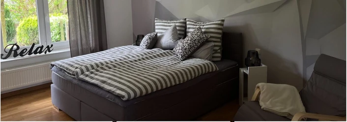 Relax Ferienwohnung Bollmeier Nettelstedt Elegante Ferienwohnung mit modernem Doppelbett, dekorativen Kissen und entspannender Atmosphäre.