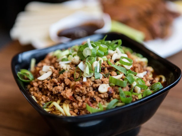 Restaurant Great Wall Close-up of a small porcelain bowl filled with fried minced meat and spring onions.