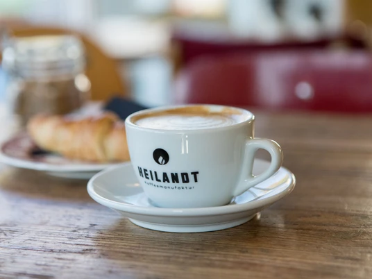 Cafe Heilandt Nahaufnahme einer Tasse Cappucchino und Croissant.Close-up of a cup of cappuccino and croissant.