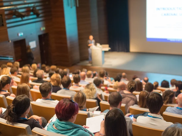 Business speaker giving a talk in conference hall. Business-Redner hält einen Vortrag in einem Konferenzsaal.