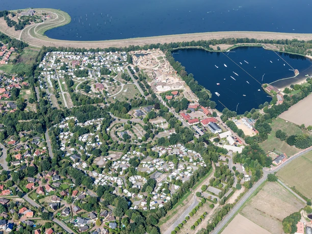 Luftbild Alfsee Luchtfoto van een camping aan het meer, omgeven door groene weiden en bomen.