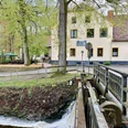 Restaurant Zur Mühle im Nettetal mit Terrasse und angrenzendem Bachlauf in grüner Umgebung.