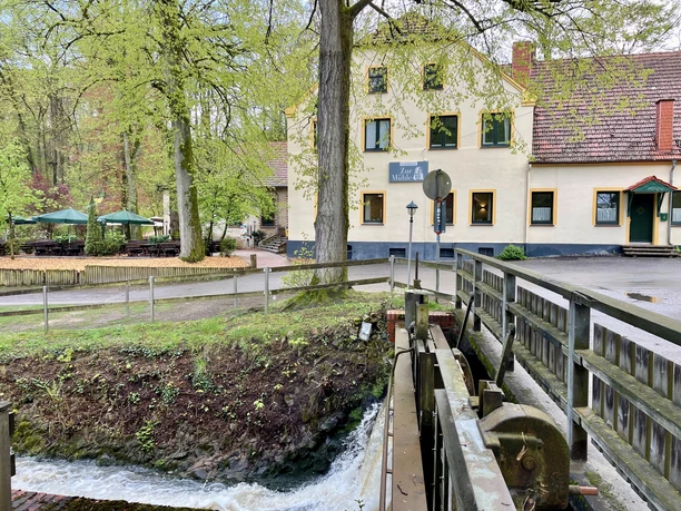 Restaurant Zur Mühle im Nettetal mit Terrasse und angrenzendem Bachlauf in grüner Umgebung.