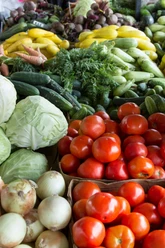 Wochenmarkt_pexels.jpg Frisches Gemüse mit Tomaten, Kohl, Zucchini und Möhren auf einem belebten Marktstand ausgebreitet.