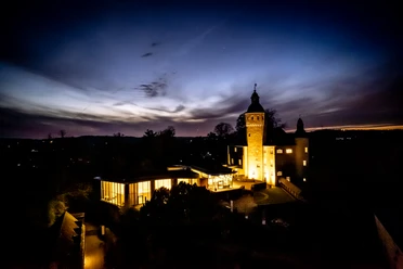Schloss Homburg Schloss Homburg bei Nacht, stimmungsvoll beleuchtet vor einem dramatischen Abendhimmel.