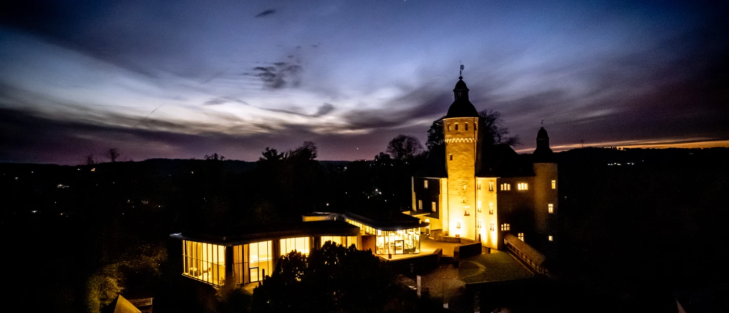 Schloss Homburg Schloss Homburg bei Nacht, stimmungsvoll beleuchtet vor einem dramatischen Abendhimmel.