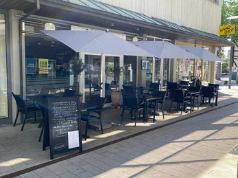 nostimo_1.jpg Gastronomieaußensitzplätze mit Sonnenschirmen in der Innenstadt mit handbeschriftetem Aufsteller mit Speisekarte
