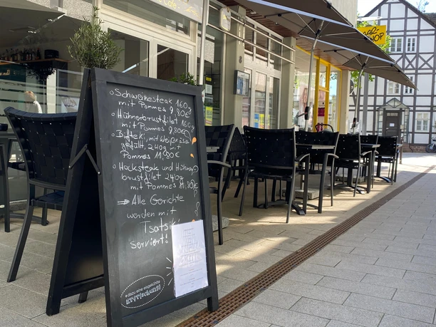 nostimo_5.jpg Gastronomieaußensitzplätze in der Innenstadt mit handbeschriftetem Aufsteller mit Speisekarte