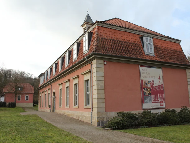 Romantik Bad Rehburg Historisches Gebäude von Romantik Bad Rehburg mit rotem Dach, Parkplätzen und gepflegtem Rasen.