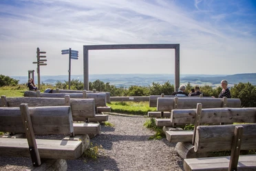 Freiluftkino auf dem Köterberg, Holzbänke mit Aussicht auf weite Hügel und geführte Wanderwege.