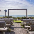 Freiluftkino auf dem Köterberg, Holzbänke mit Aussicht auf weite Hügel und geführte Wanderwege.