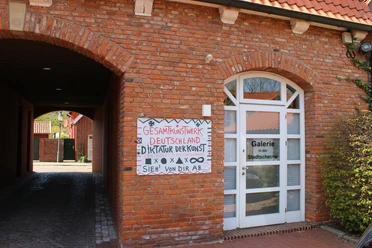 Galerie in der Stadtscheune - Nordseebad Otterndorf Historischer Backsteinbau mit Torbogen, Kunstplakat und Tür zur Galerie in der Stadtscheune.