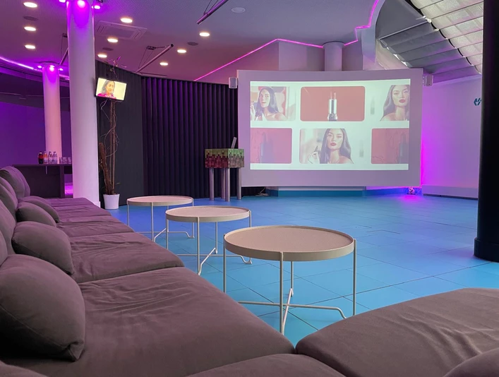 Tagung Ein großes Sofa steht vor einer großen LeinwandA large sofa stands in front of a large screen.