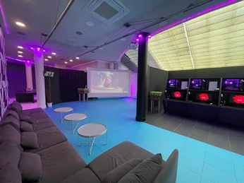 Lounge + Work Gaming und Chill Out Bereich mit Sofa und einer großen Leinwand im HintergrundGaming and chill-out area with sofa and large screen in the background