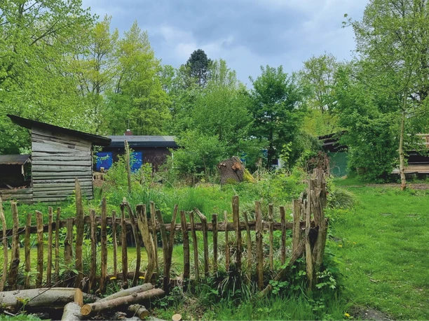 Abenteuerspielplatz Buntspecht Mehrere Holzhütten auf dem Außengelände des Abenteuerspielplatzes Buntspecht, umgeben von Bäumen und Spielflächen