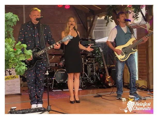 Luxus_Loft_2023_Rahmen.jpg Live-Auftritt einer Band mit Sängerin und Musikern auf einer Bühne beim Weinfest in Chemnitz.