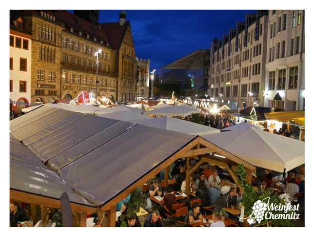 P1160905_Rahmen.jpg Weinfest auf einem belebten städtischen Platz mit vielen Besuchern und Verkaufsständen.