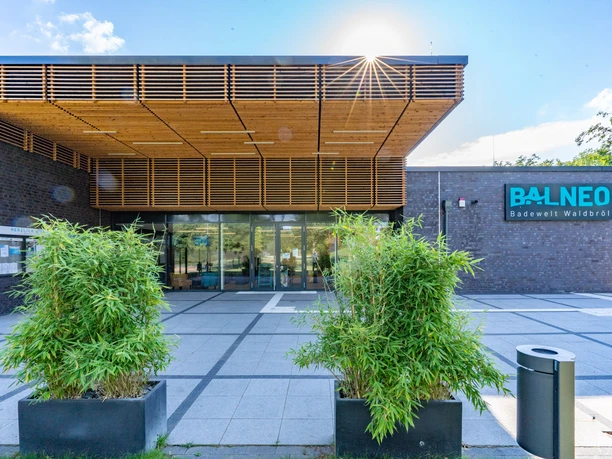 BALNEO Waldbröl Eingangsbereich der modernen Balneo-Badewelt in Waldbröl, mit Pflanzen und sonnigem Himmel im Hintergrund.