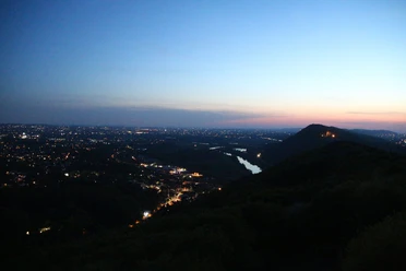 Nächtlicher Blick über Porta Westfalica mit beleuchteten Wegen und der Silhouette des Kaiserdenkmals.
