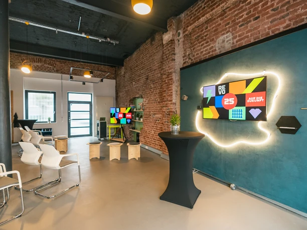 Moderner Meetingraum mit Backsteinmauer, Reihenbestuhlung und TV