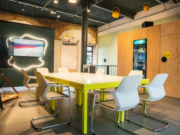 Panorama3.jpg Modern meeting room with brick wall, block seating, TV and kitchen area