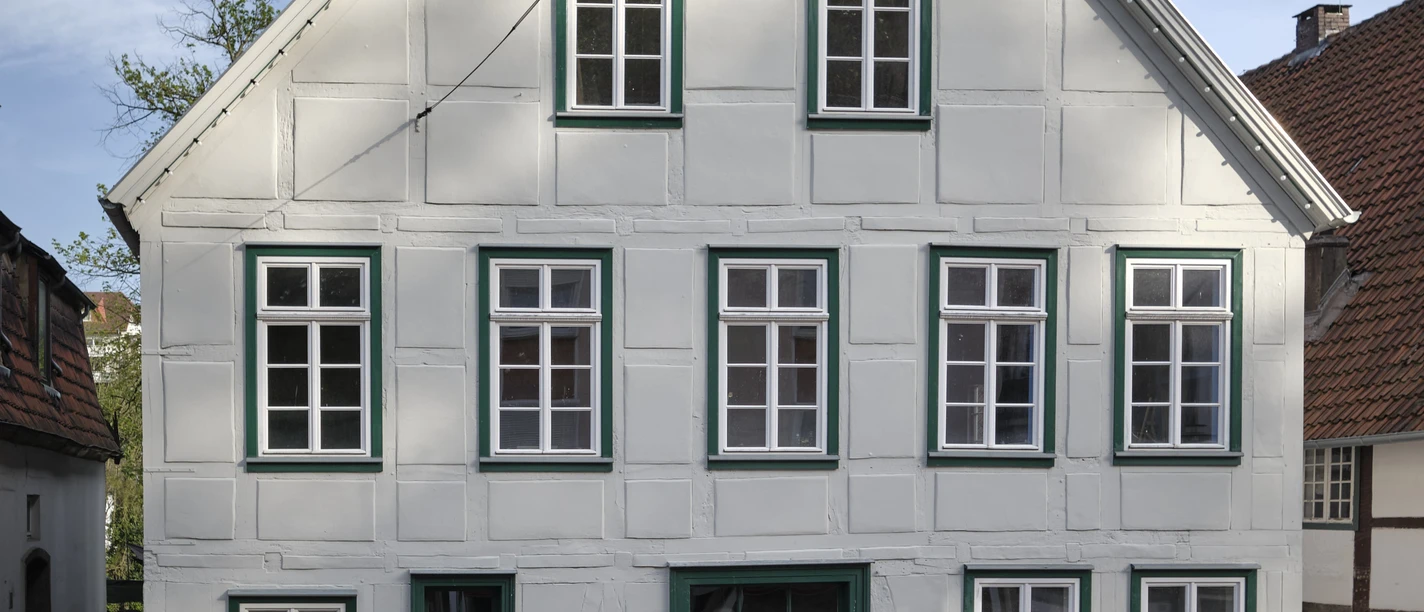 Das Poelmahn Haus in Vlotho vereint traditionelles Fachwerkdesign mit weißen und grünen Elementen.