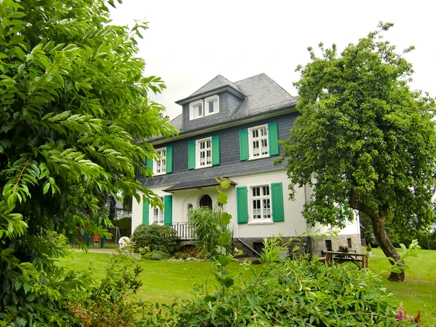 Pastorenhaus <p>Charmantes Fachwerkhaus mit grünen Fensterläden, umgeben von üppigem Garten und Bäumen.</p>