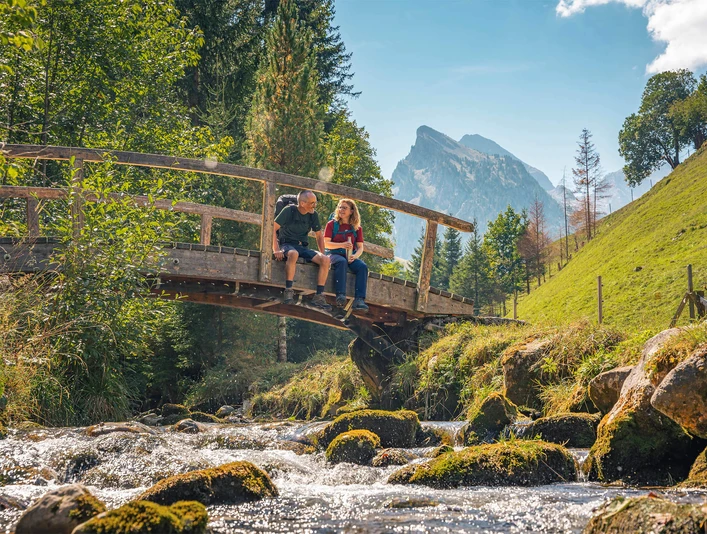 Se promener dans le parc naturel Diemtigtal Wanderer ruhen sich auf einer Holzbrücke aus und lassen die Beine baumelnHikers rest on a wooden bridge and let their legs dangleDes randonneurs se reposent sur un pont en bois et laissent leurs jambes se balancer.