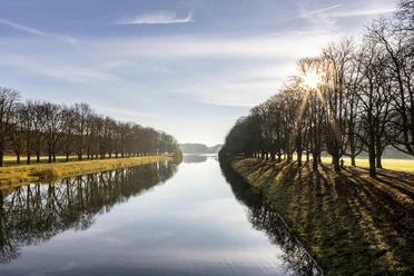 Decksteiner Weiher Der Decksteiner Weiher in Köln, umgeben von sonnenbeschienenen Winterbäumen, reflektiert das klare Himmelblau.